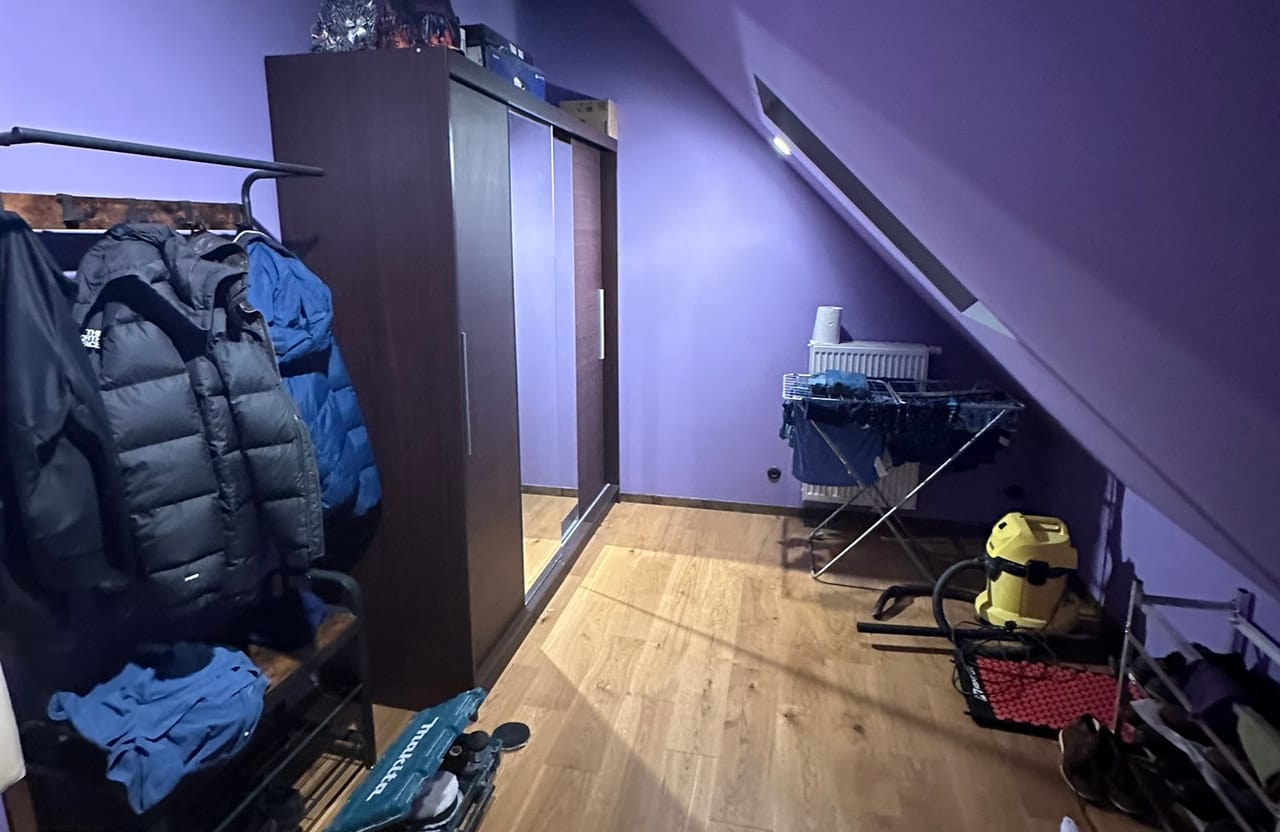Pokój na poddaszu z podłogą z paneli, oświetlony taśmą LED w kolorze fioletowym